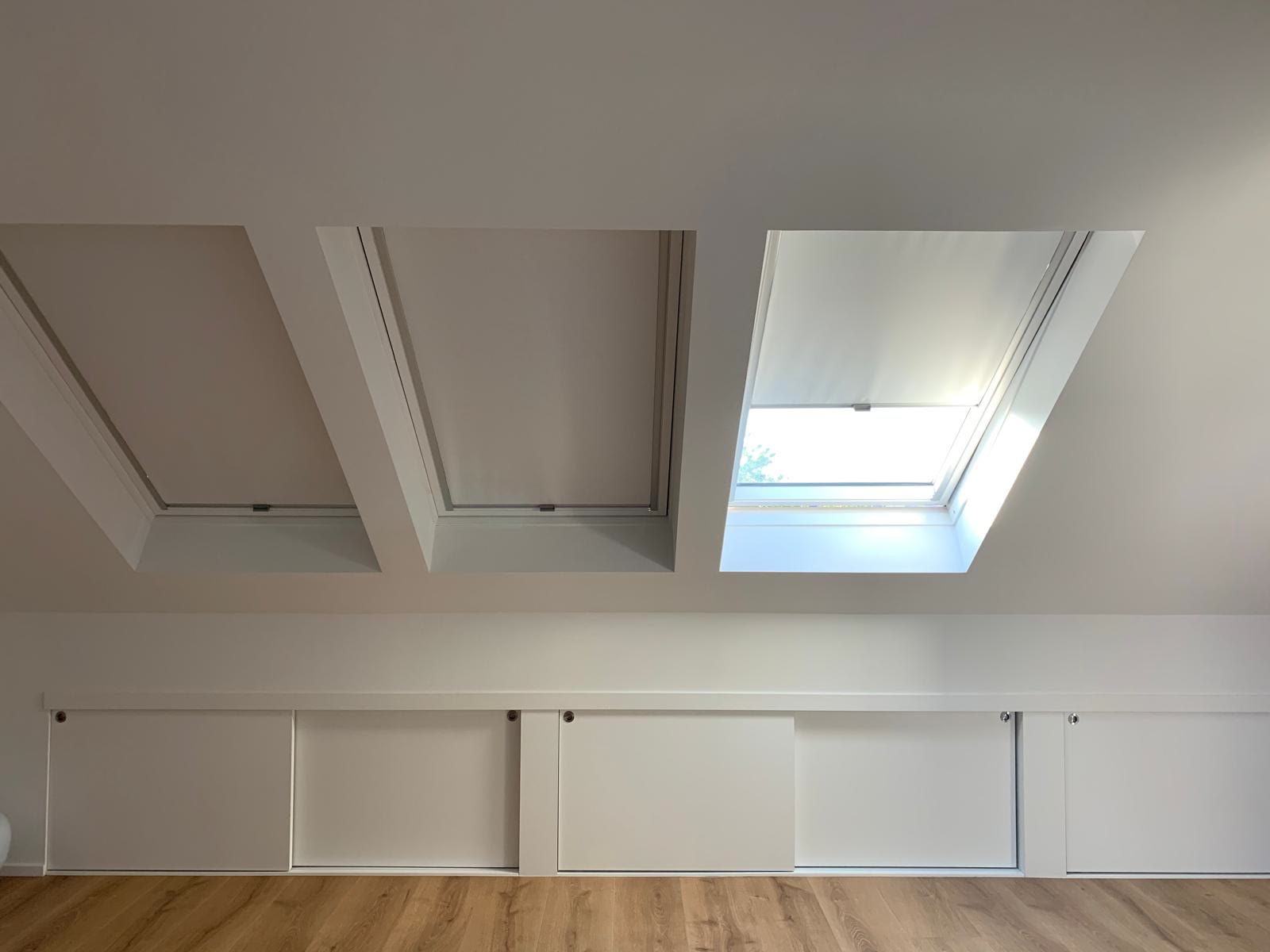 Attic room with white ceiling and roof windows